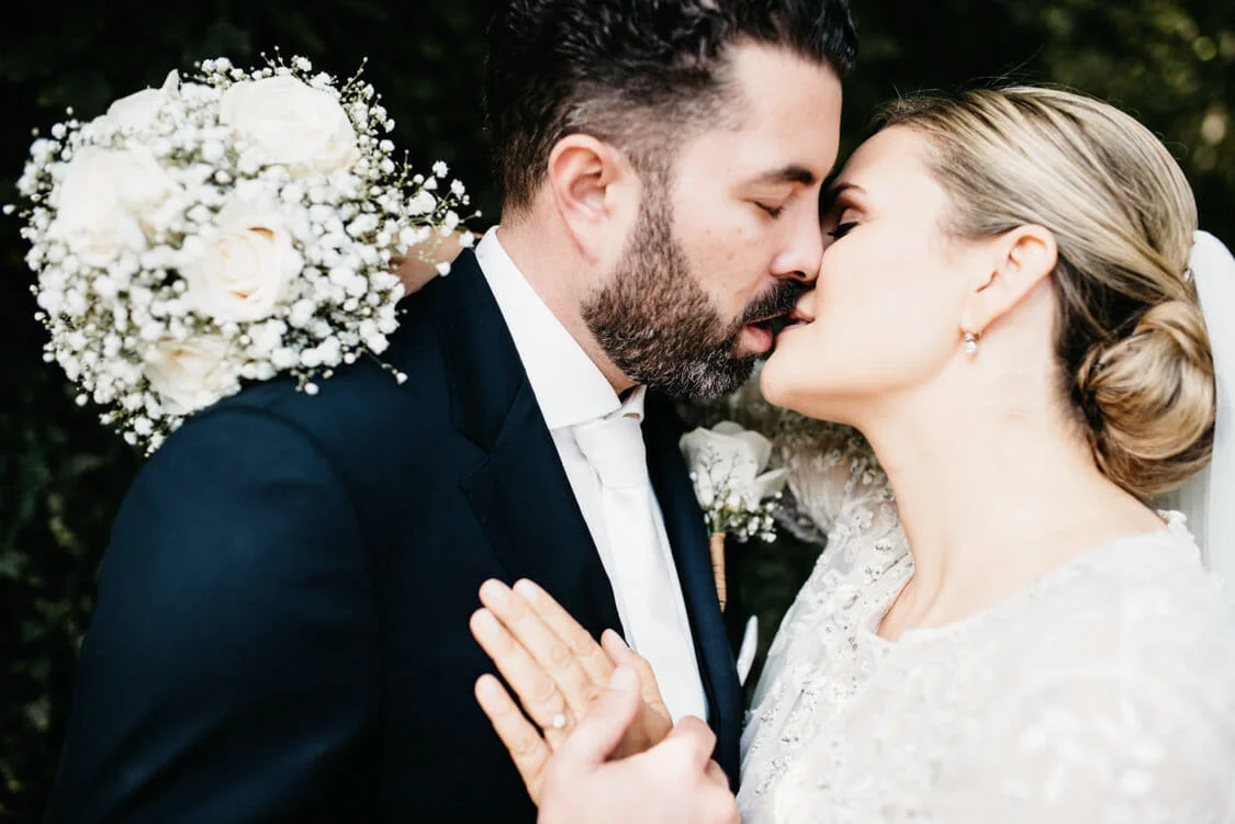 Stephanie und Christian küssen sich bei ihrer Hochzeit am Schloss Fuschl