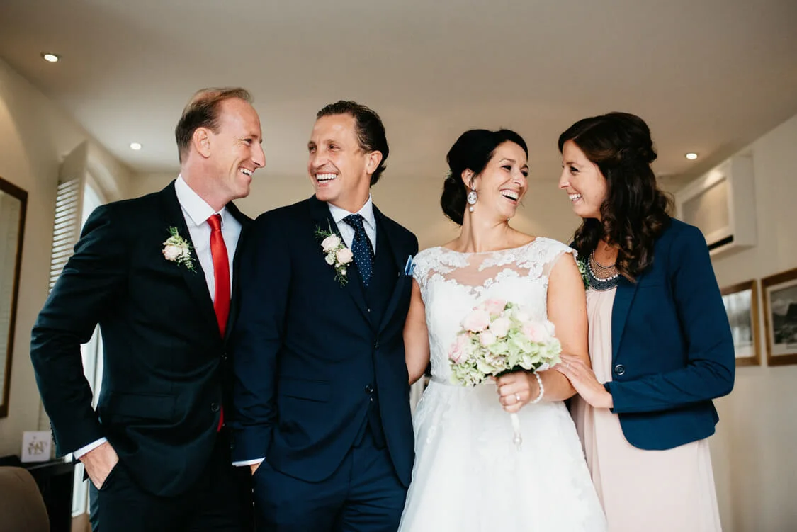 Theresa und Stephan lachen mit ihren Gästen bei ihrer Hochzeit